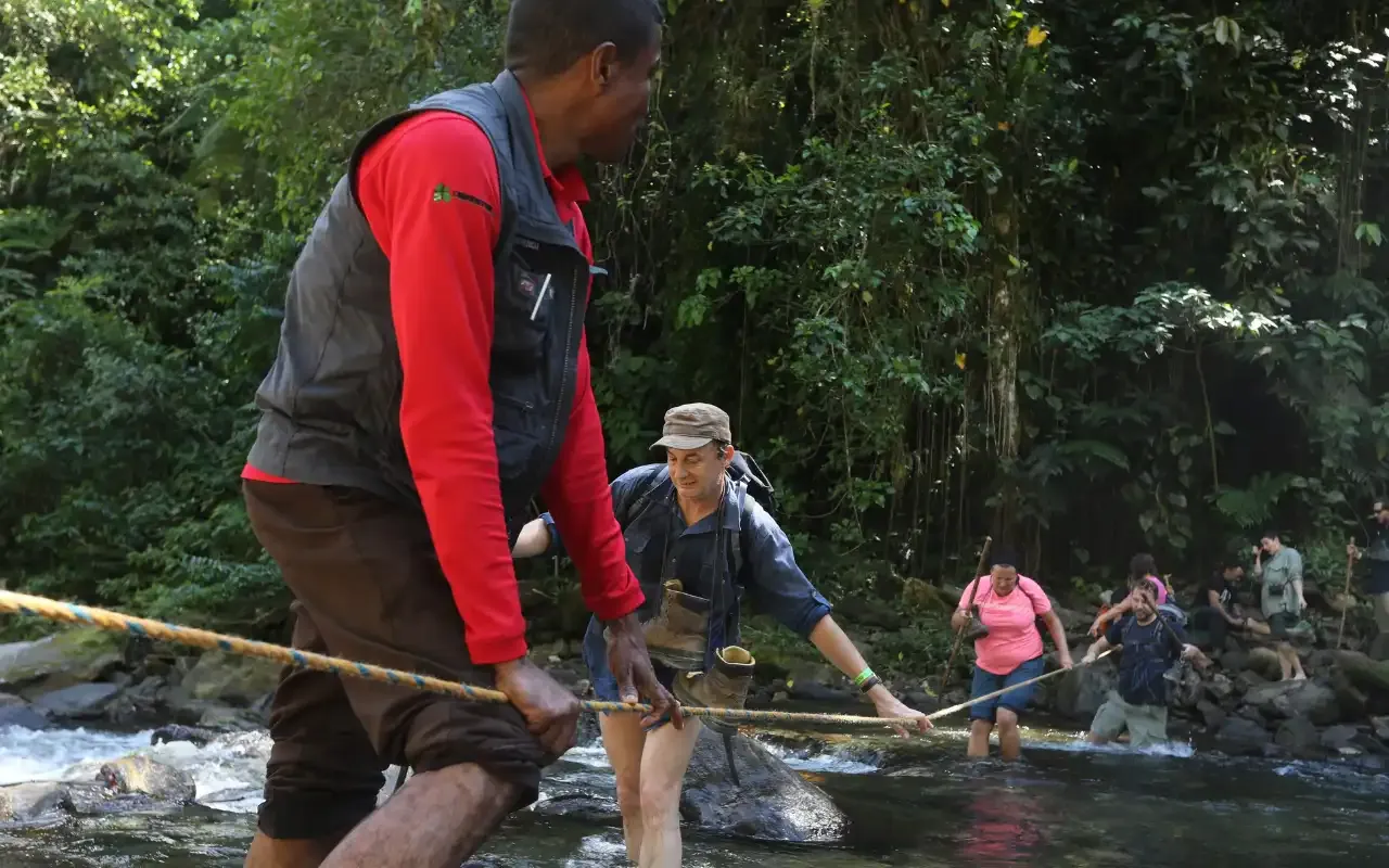 Group crossing a knee-deep river on the second day of the trek.