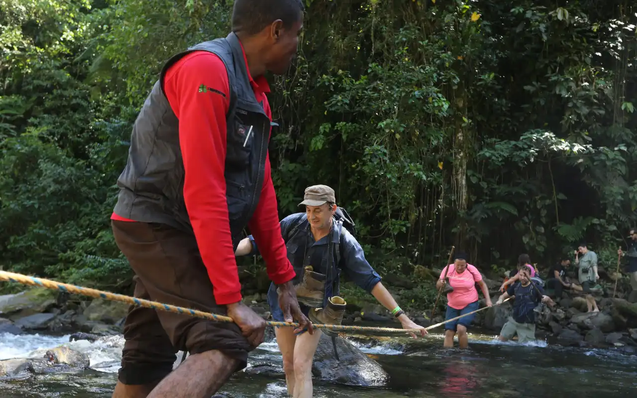 Group crossing a knee-deep river on the second day of the trek.